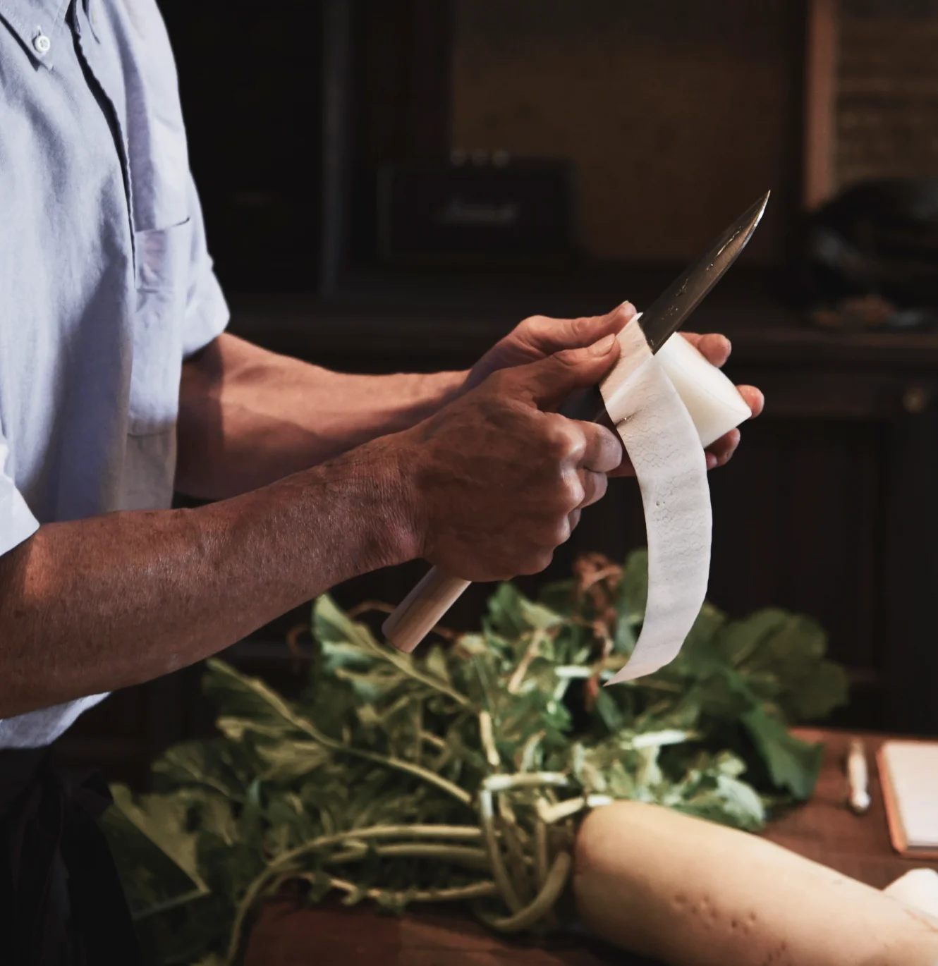 Hand peeling daikon with a chef's knife