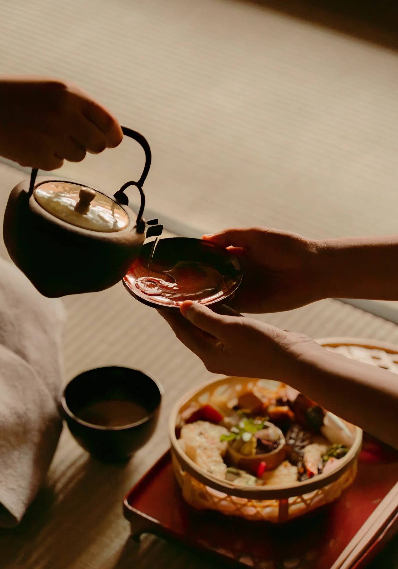 Pouring tea from a kettle into a bowl