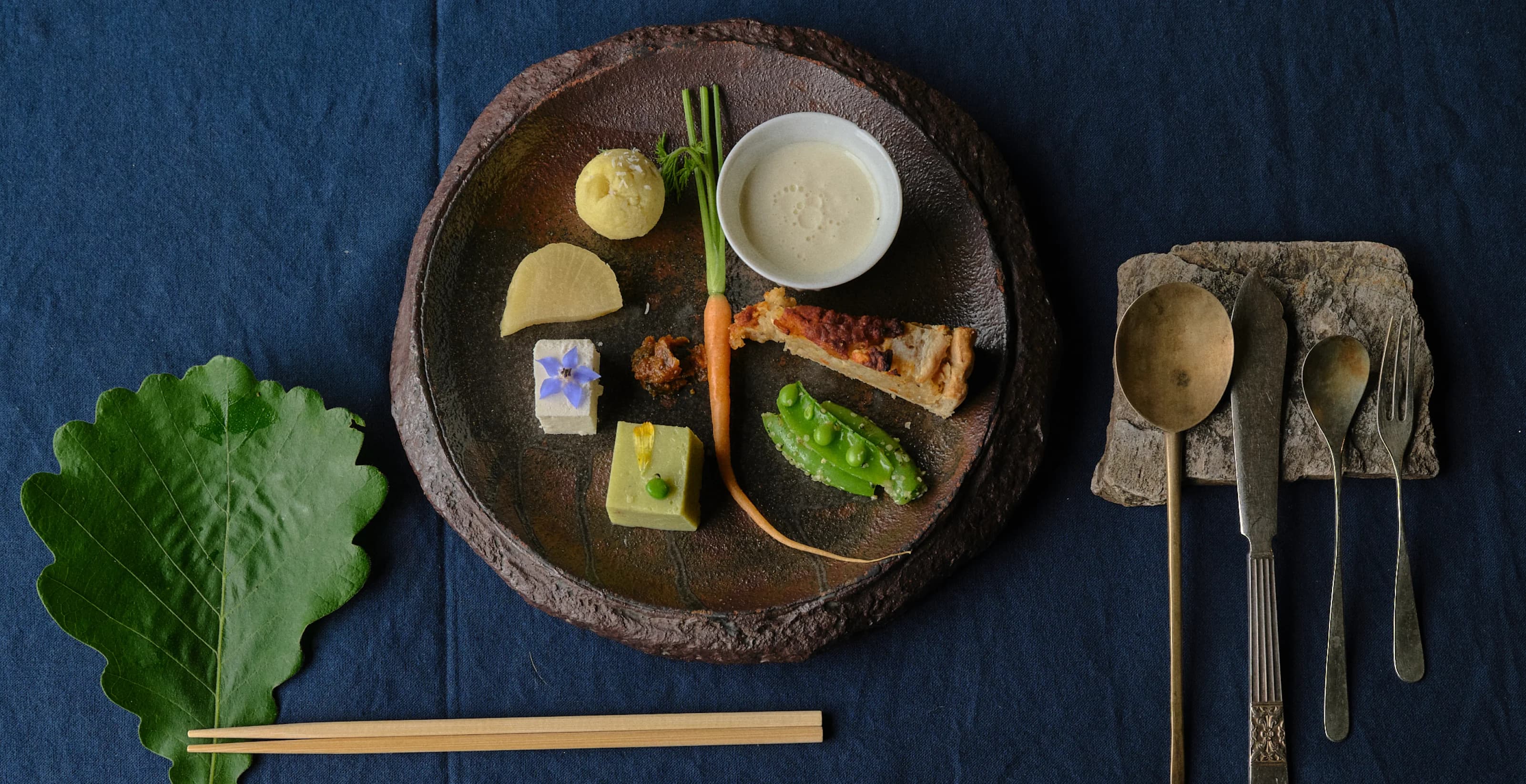 Small bites arranged on a wooden plank and in a bowl.