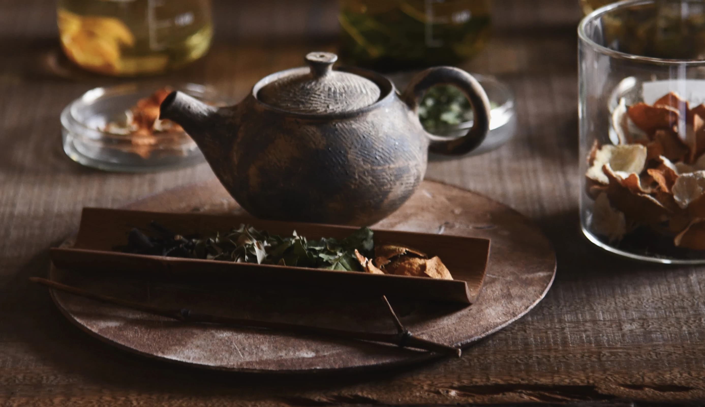 A hand touching a plate with flowers and tea