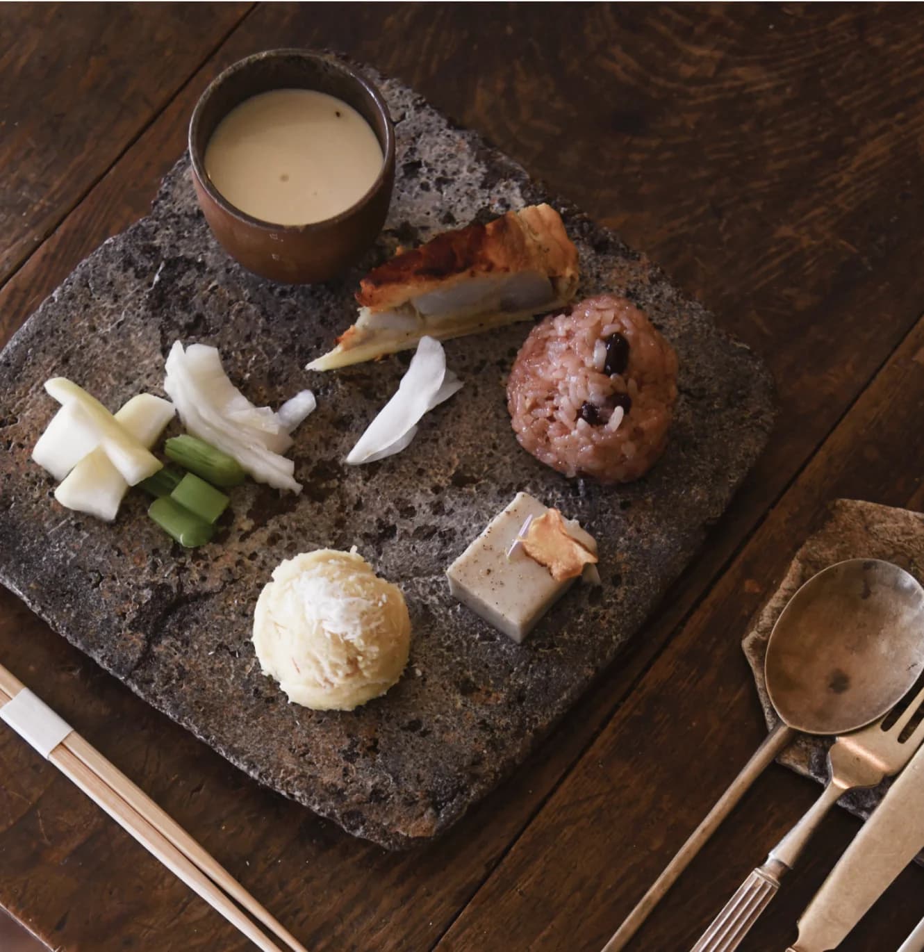 Assorted small bites and tea served on a stone plate