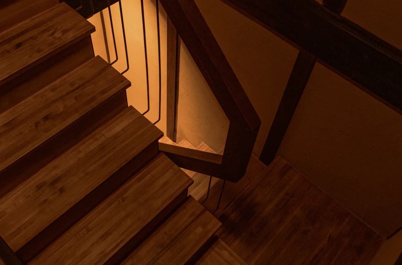 Wooden staircase with iron railing viewed from above