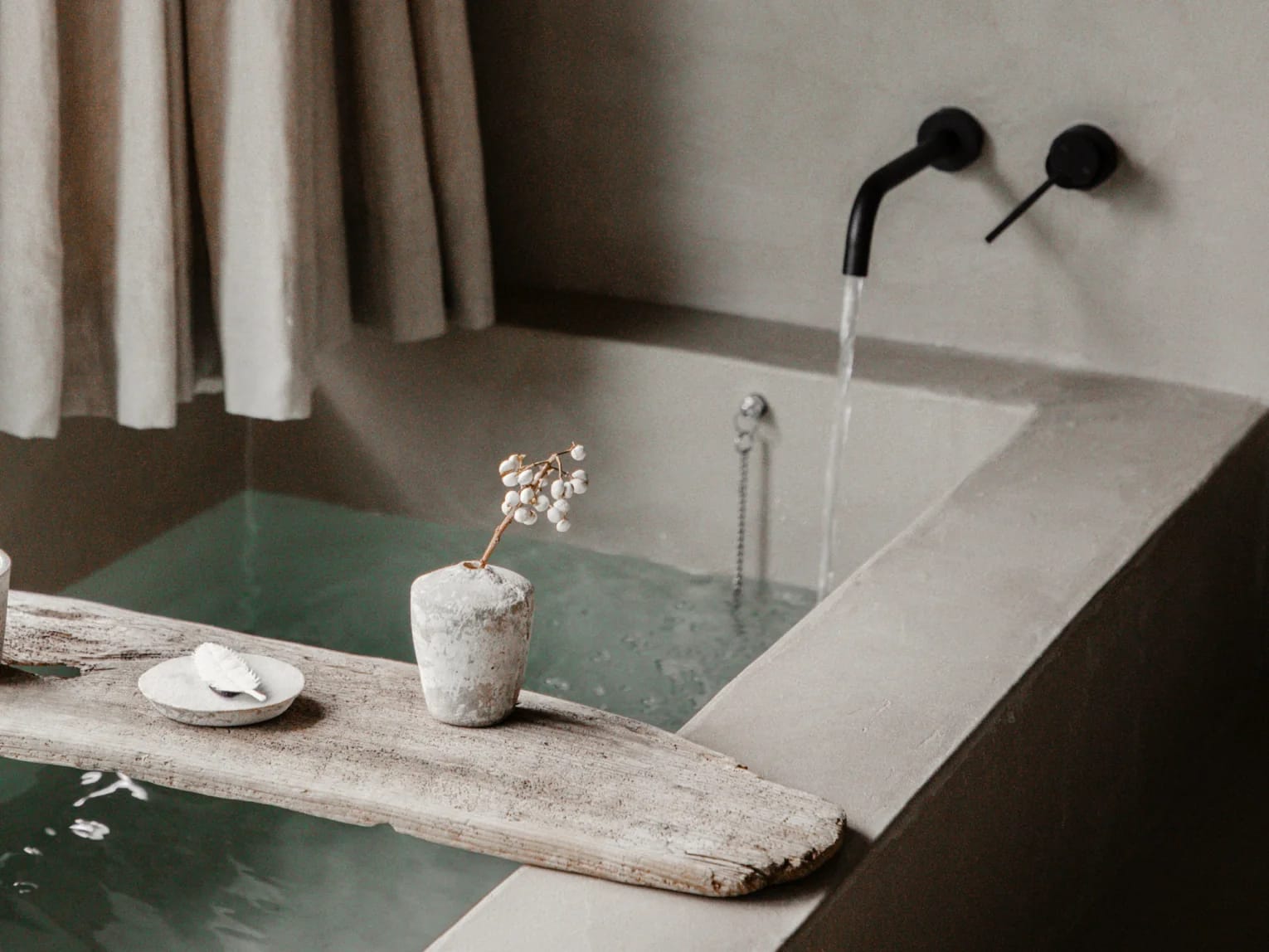 Suite 1 bathtub with a wooden tray and vase