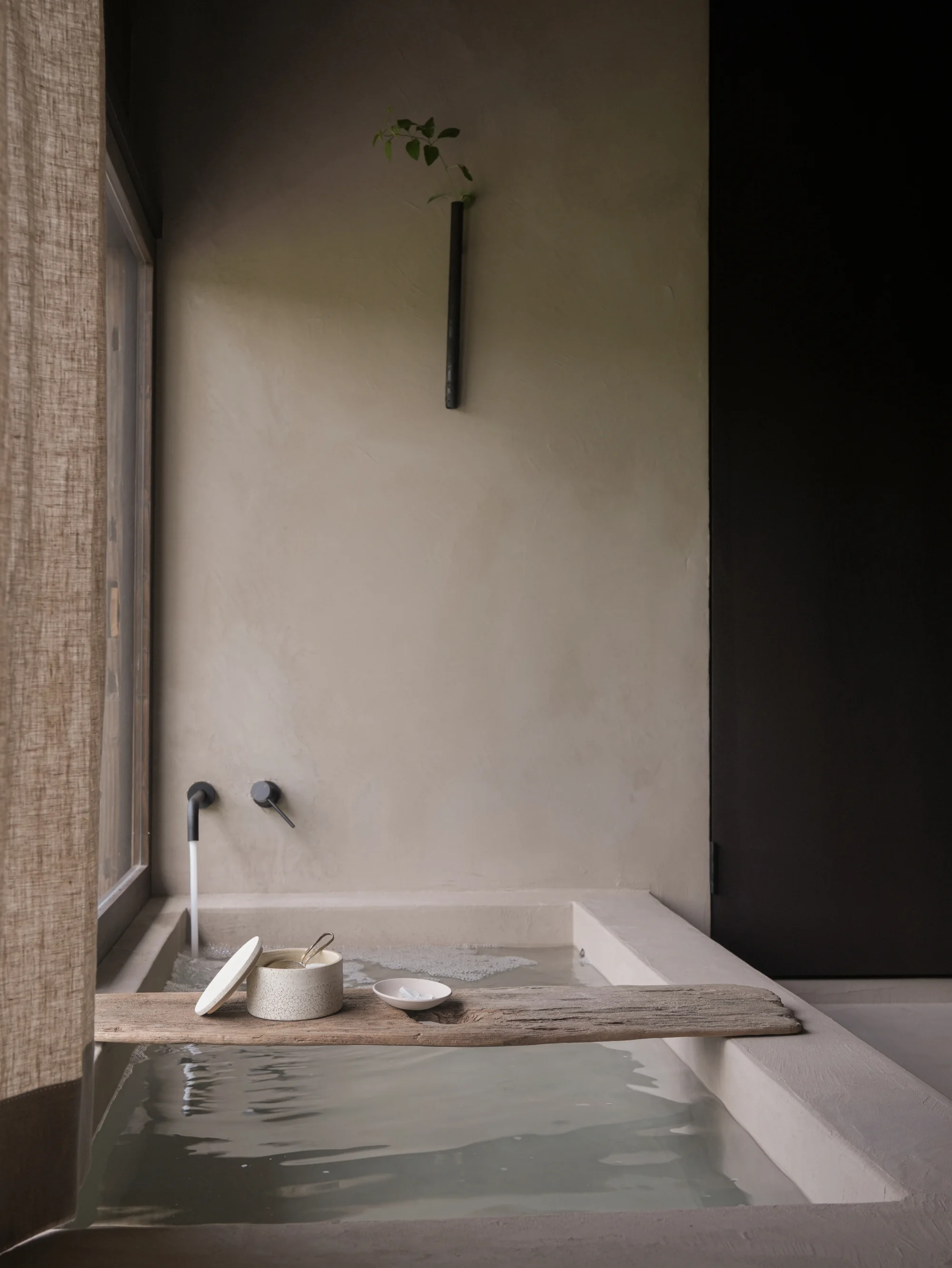 Suite 1 soaking tub with a wooden bath tray by the window
