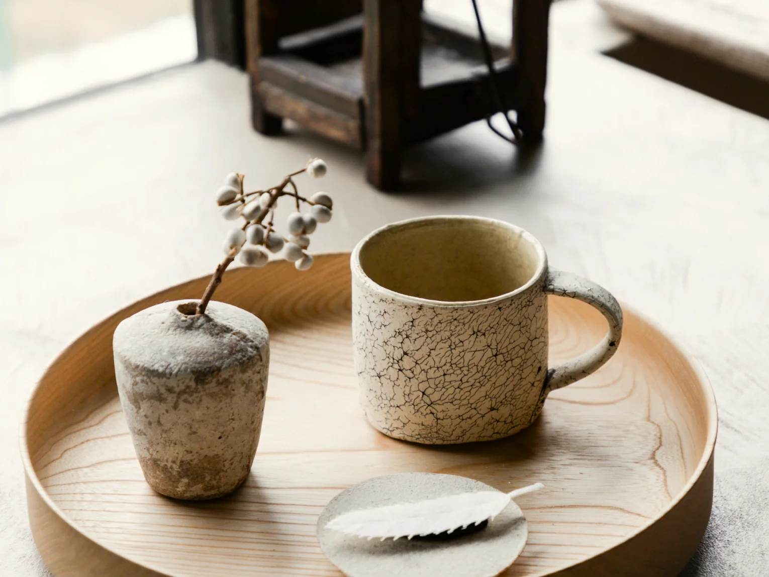 Ceramic cup and vase on a wooden tray in Suite 1