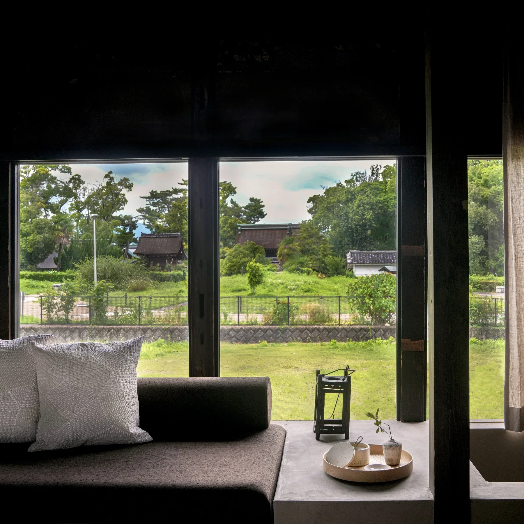 Suite 1 window framing the greenery and rooftops of Toyokuni Shrine